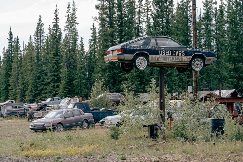 Used car mounted on pole above junkyard