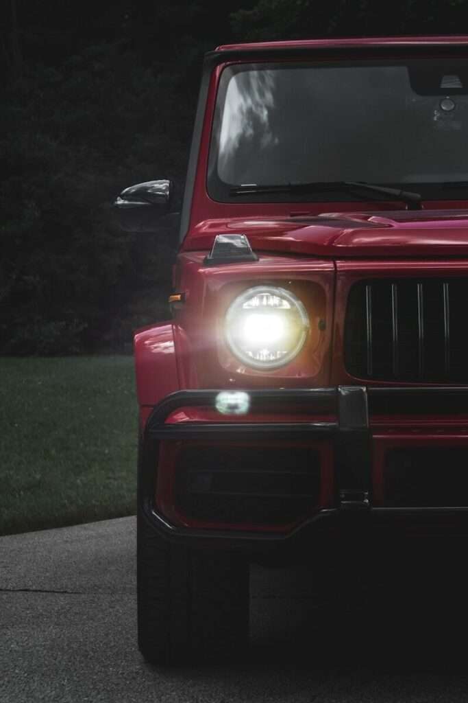a red jeep is parked on the side of the road