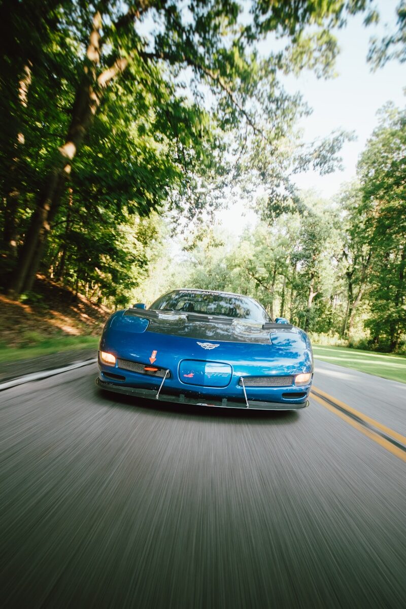A blue sports car driving down the road