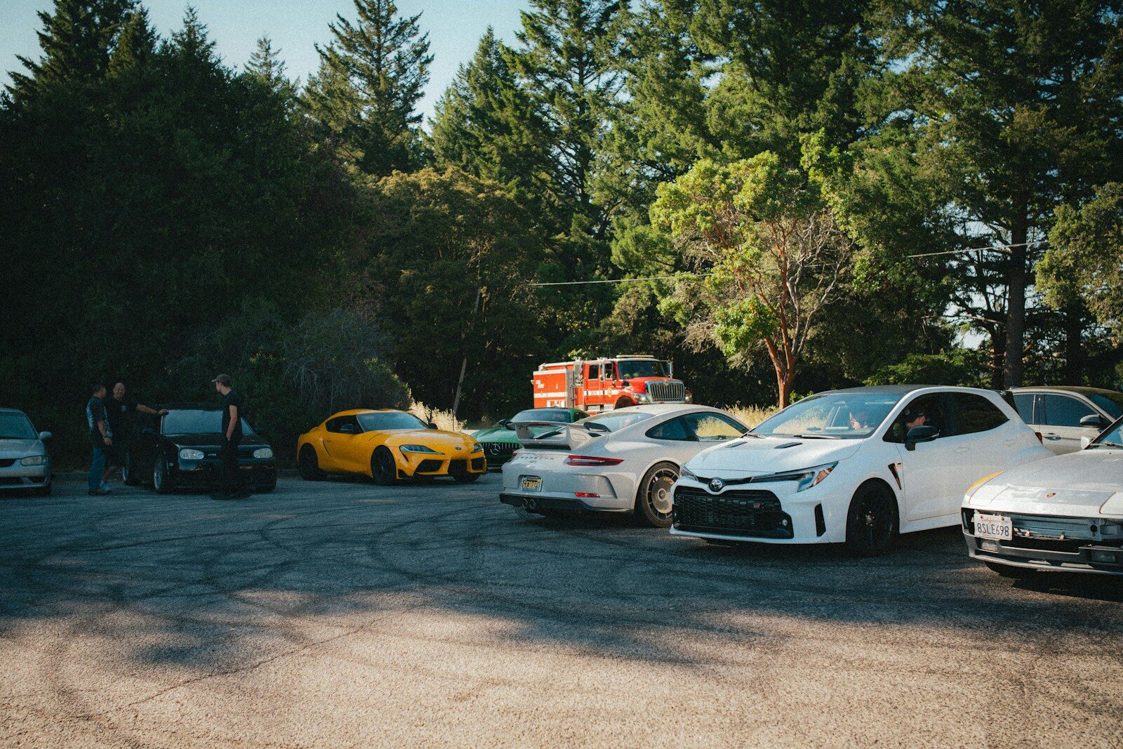 Cars parked on a lot, with a fire truck.