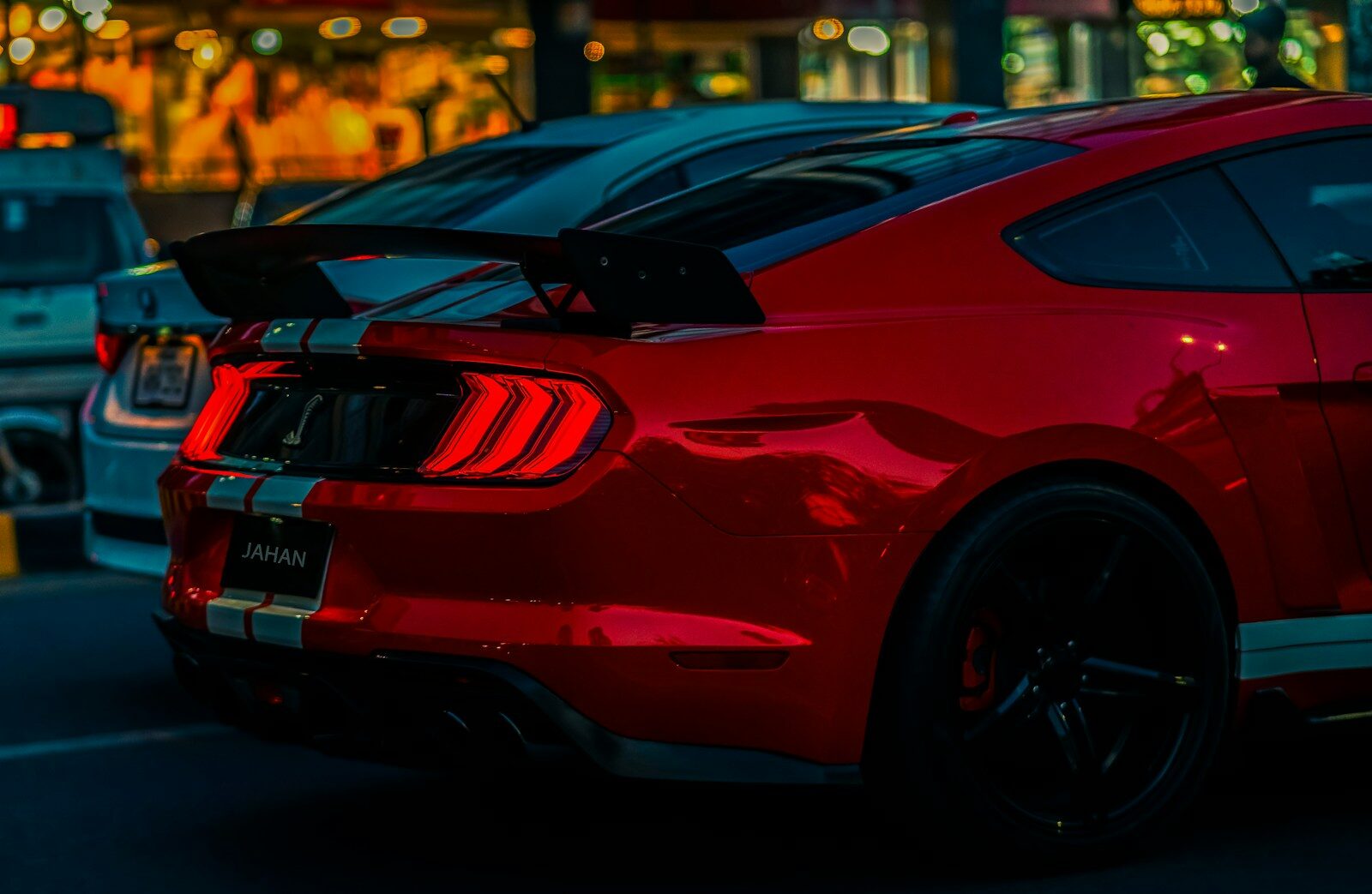 a red mustang mustang parked in a parking lot