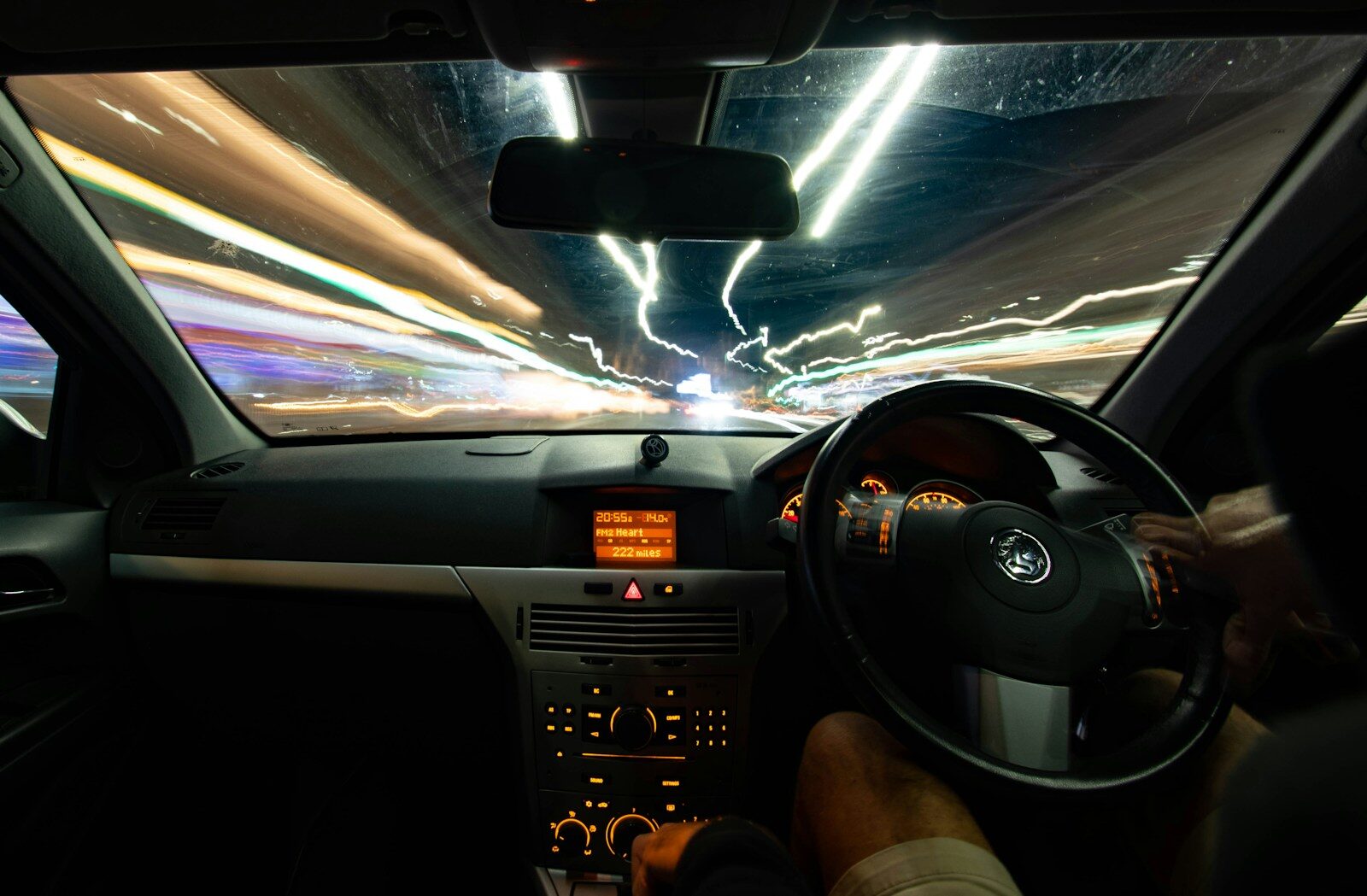 a car driving down a street at night