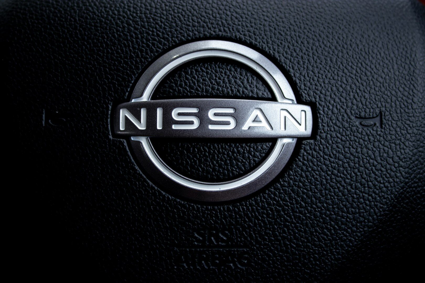 Close-up of a nissan car steering wheel logo.