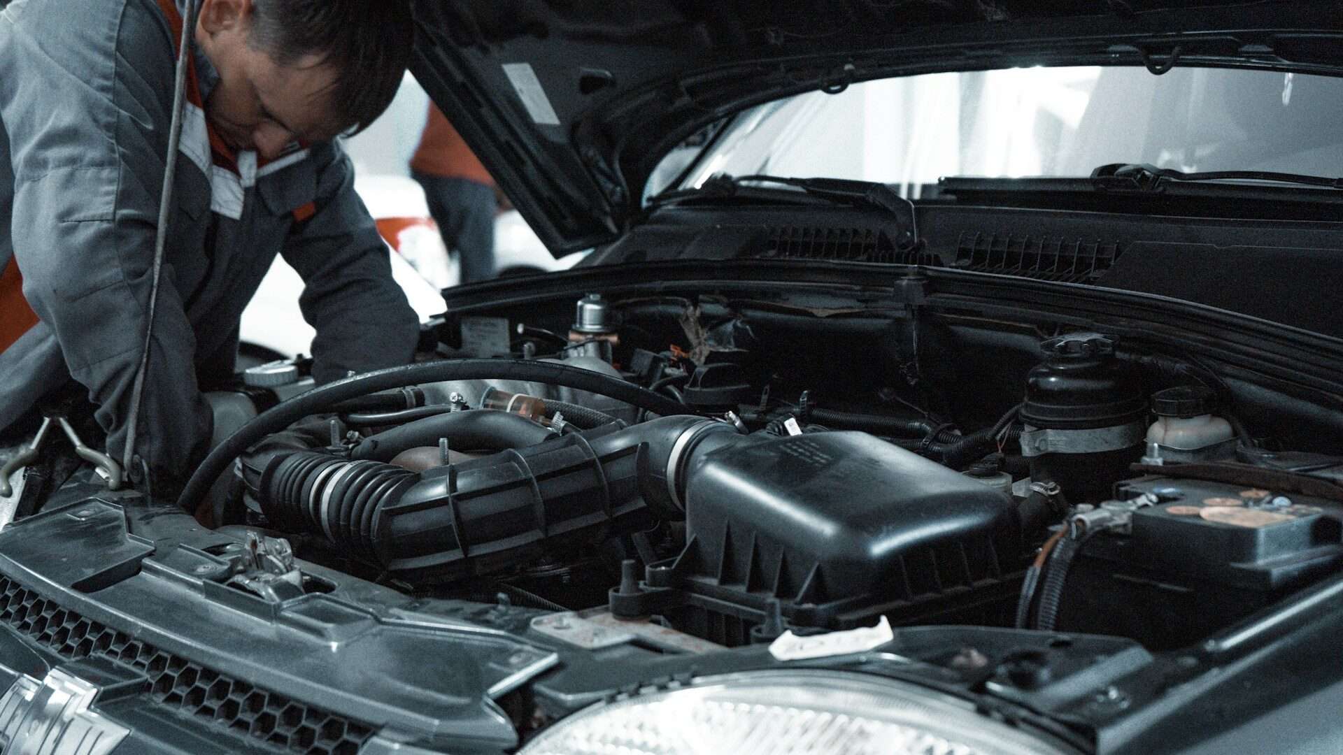 Mechanic inspecting a car engine during routine maintenance
