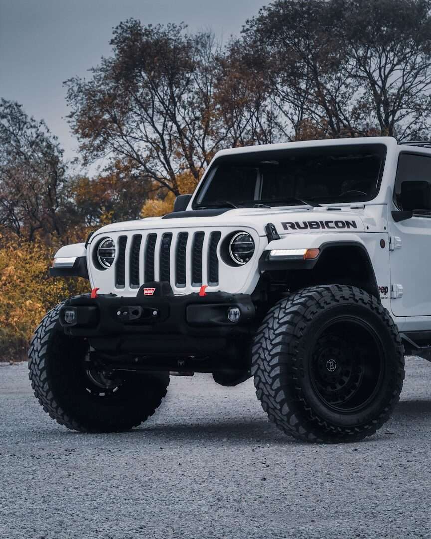 a white jeep is parked in a parking lot
