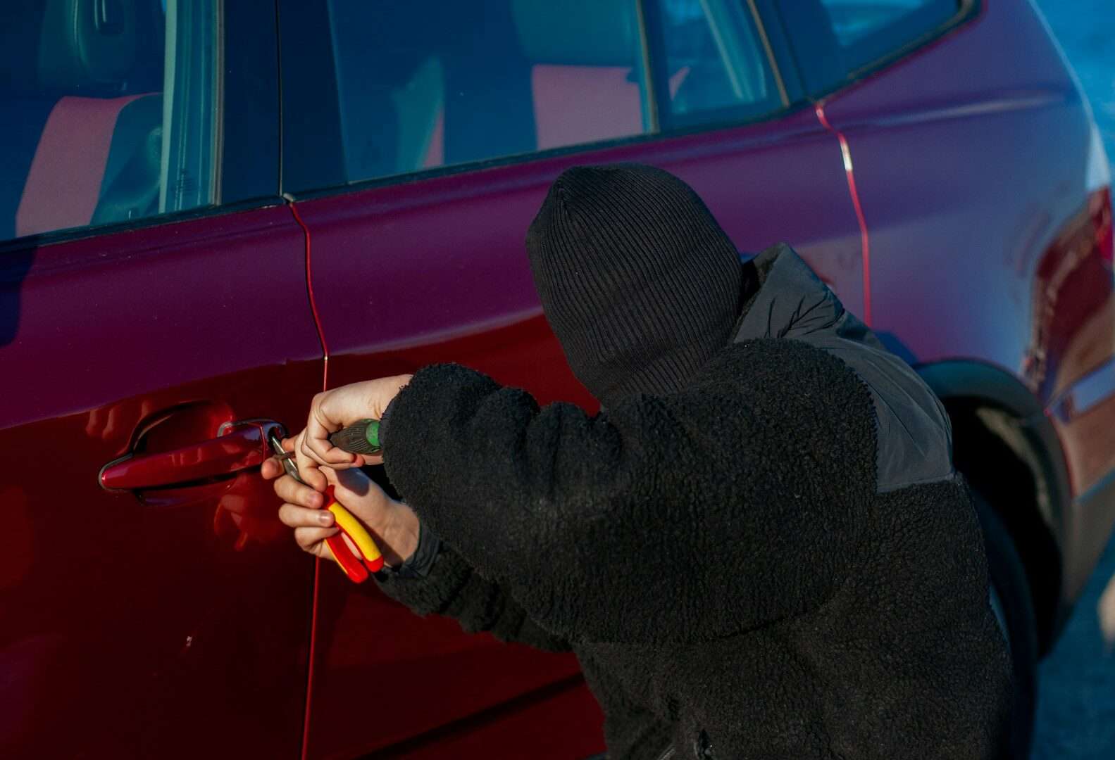 A person is trying to break into a car.