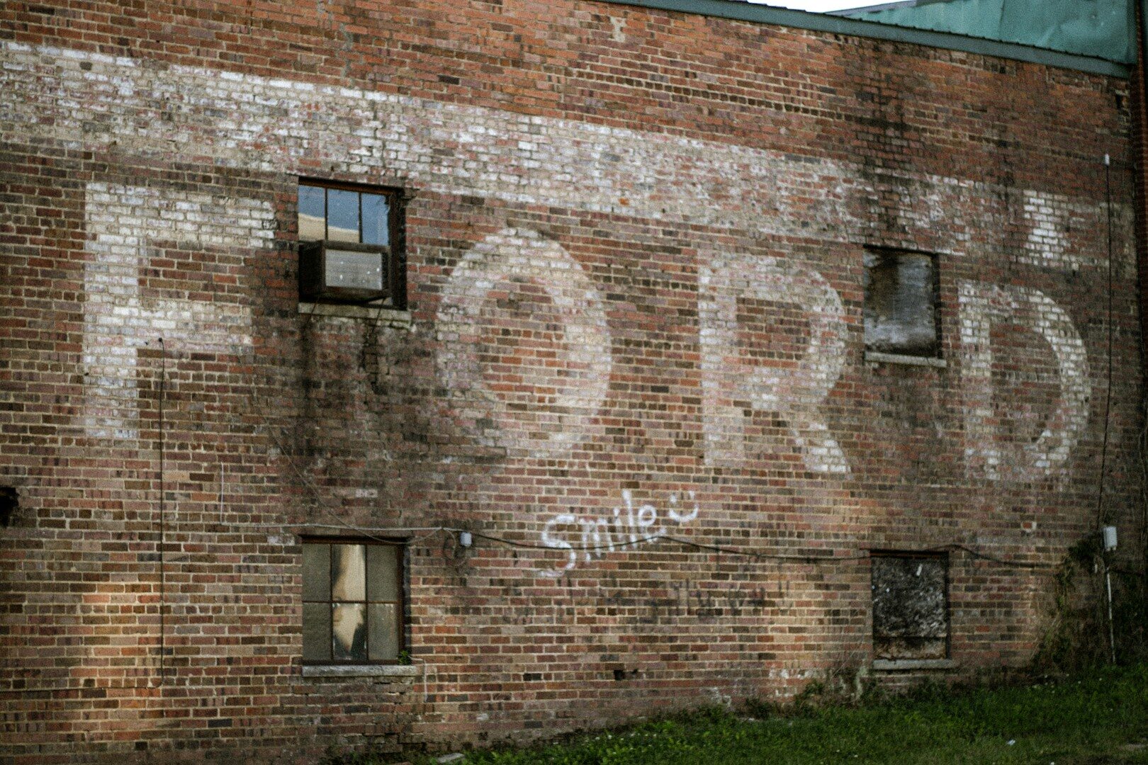 a brick building with graffiti on it