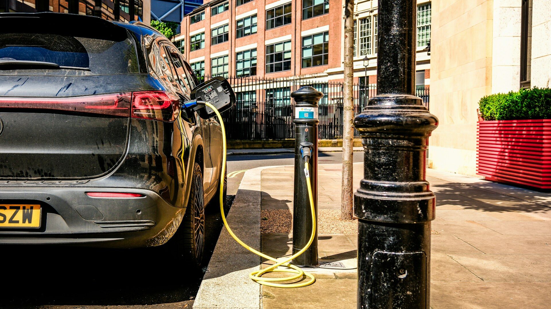 A small electric car charging on a European city street, representing the low-cost EVs Stellantis now imports through its Leapmotor joint venture