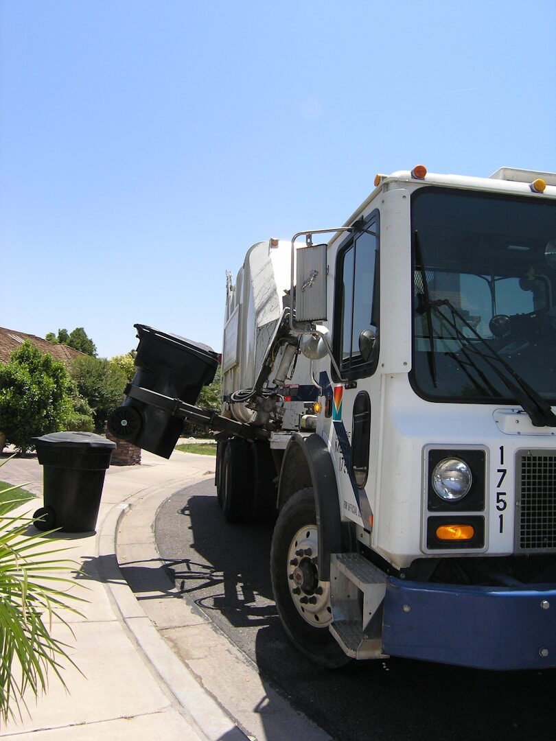 Garbage truck on a residential street, the kind of municipal vehicle cities are now equipping with AI code-enforcement cameras