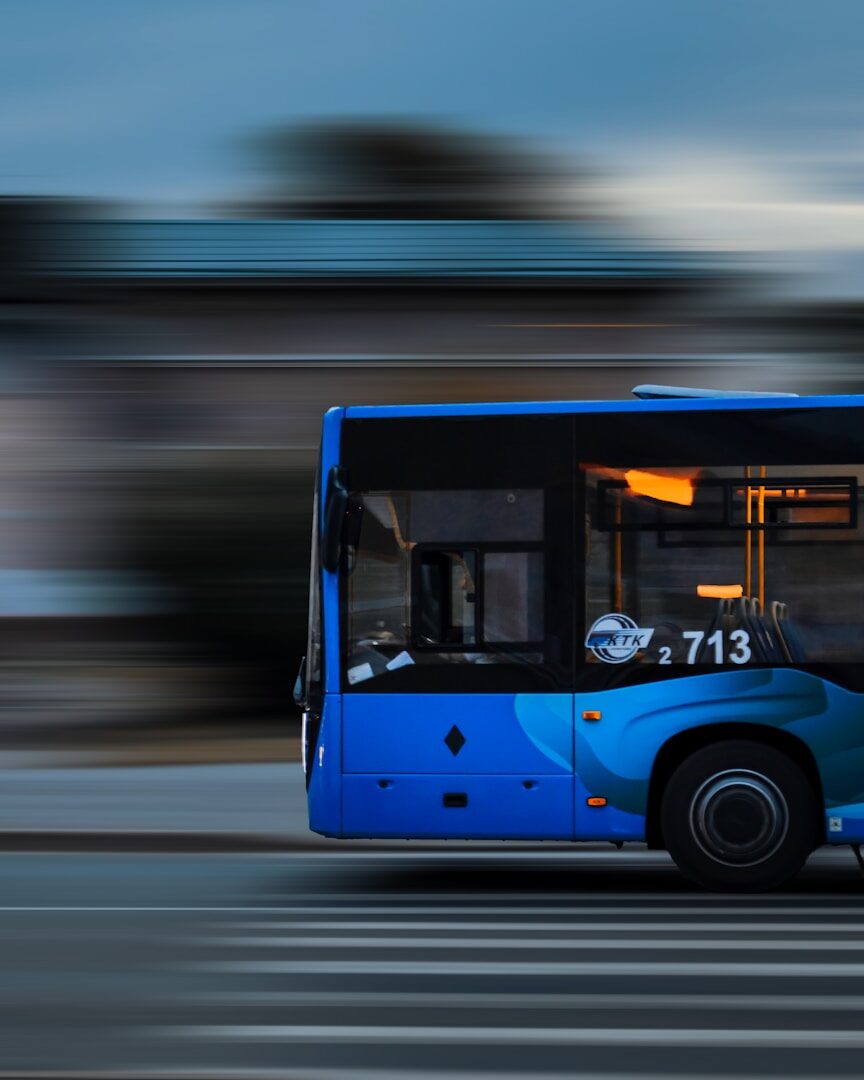 A blue electric transit bus in motion, representing the remote kill switch built into over-the-air vehicle software updates