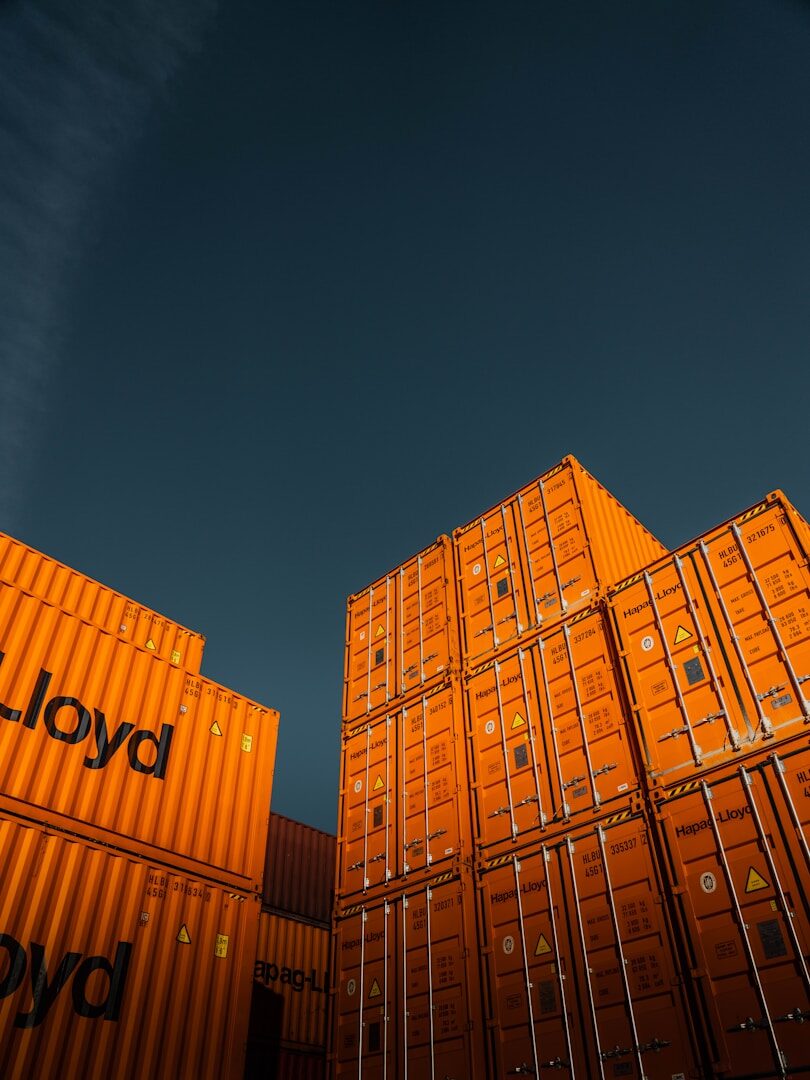 Stacked shipping containers, representing the global parts supply chain behind EV manufacturing and tariffs