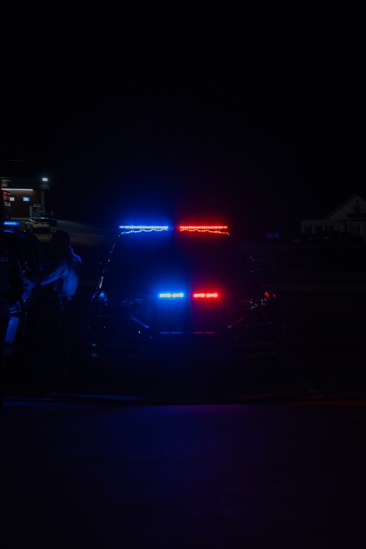 A police car parked on the side of the road at night