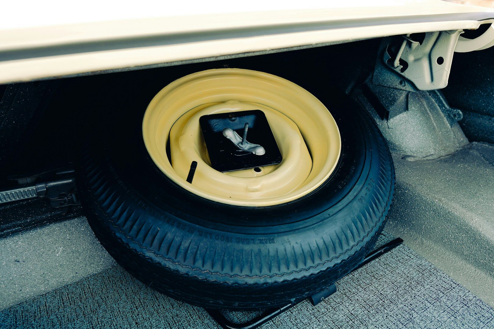 Spare tire and jack in car trunk