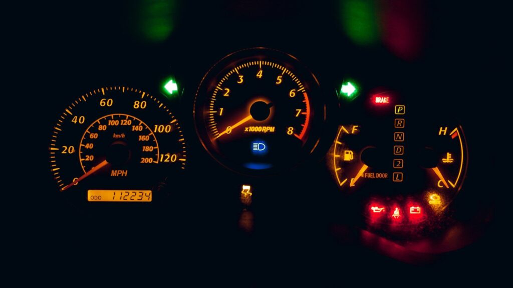 Analog instrument cluster with speedometer and warning lights, illustrating the gauges a digital combination meter replaces