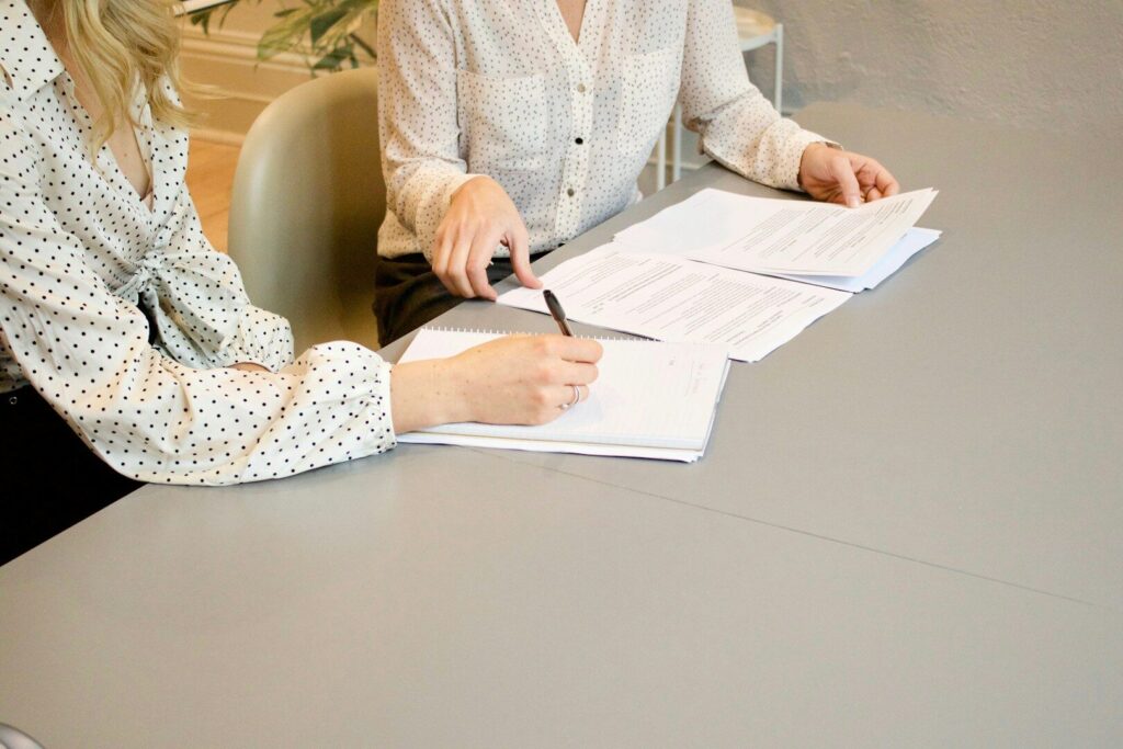 Customer signing auto loan financing paperwork at a car dealership