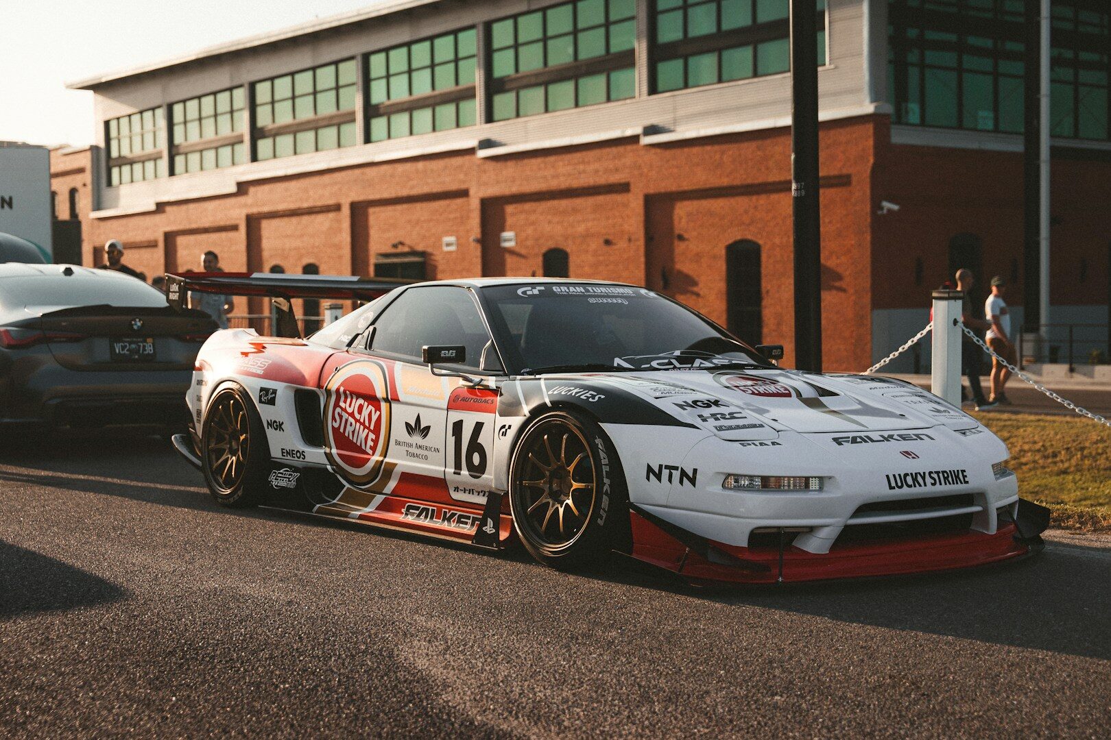 A white race car with sponsor decals parked outside.