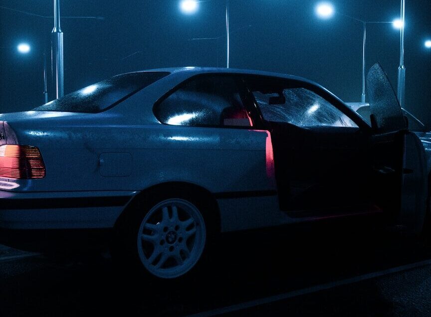 a white car parked in a parking lot at night