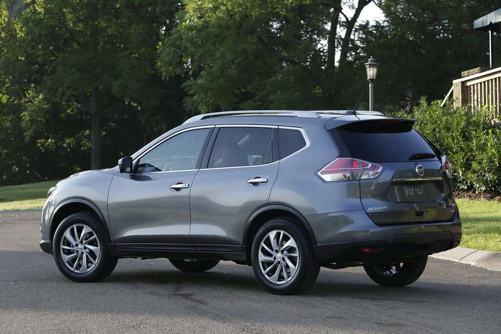 Rear three-quarter view of a grey Nissan Rogue crossover parked on a driveway