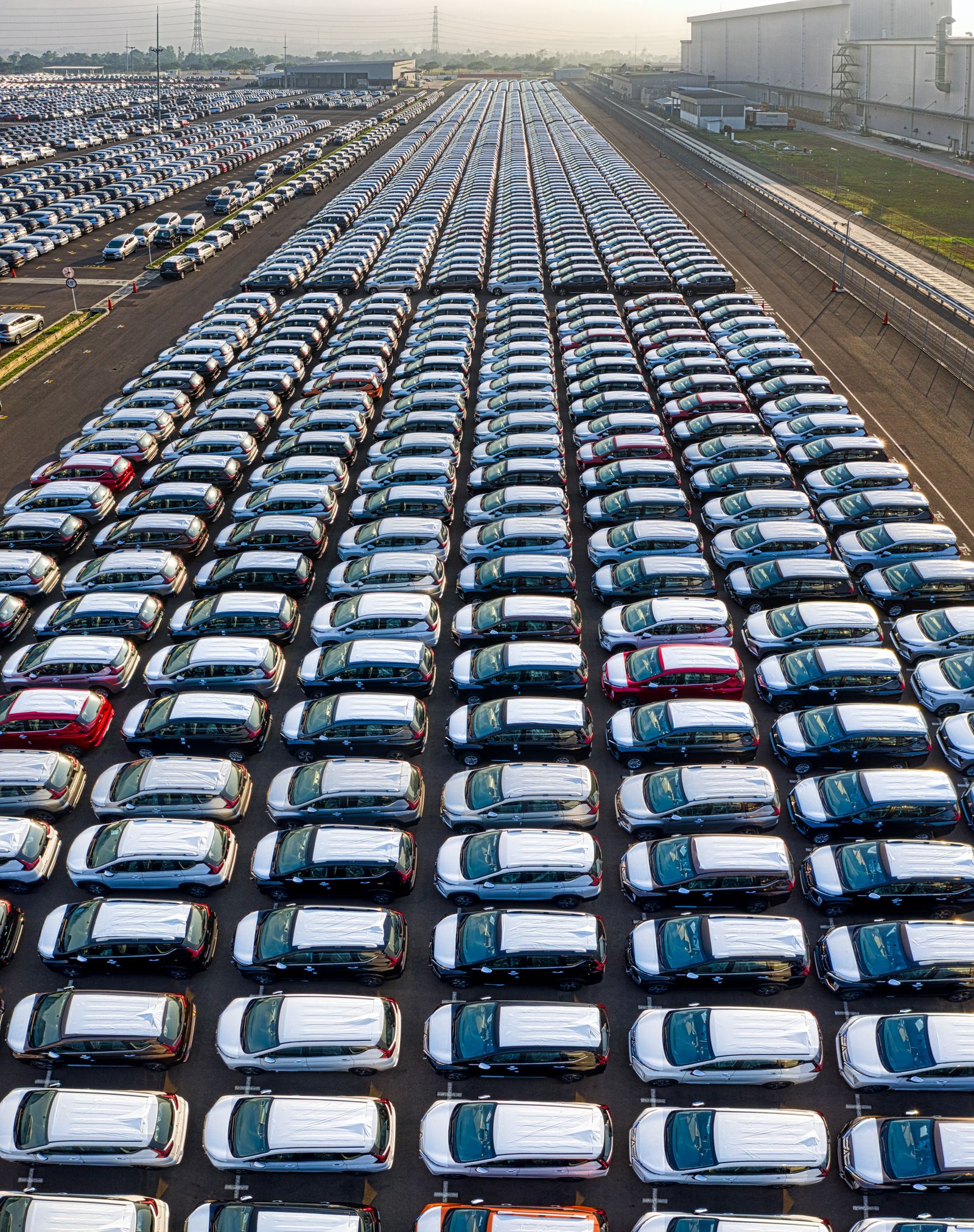 Aerial view of rows of new cars parked in a vehicle storage lot