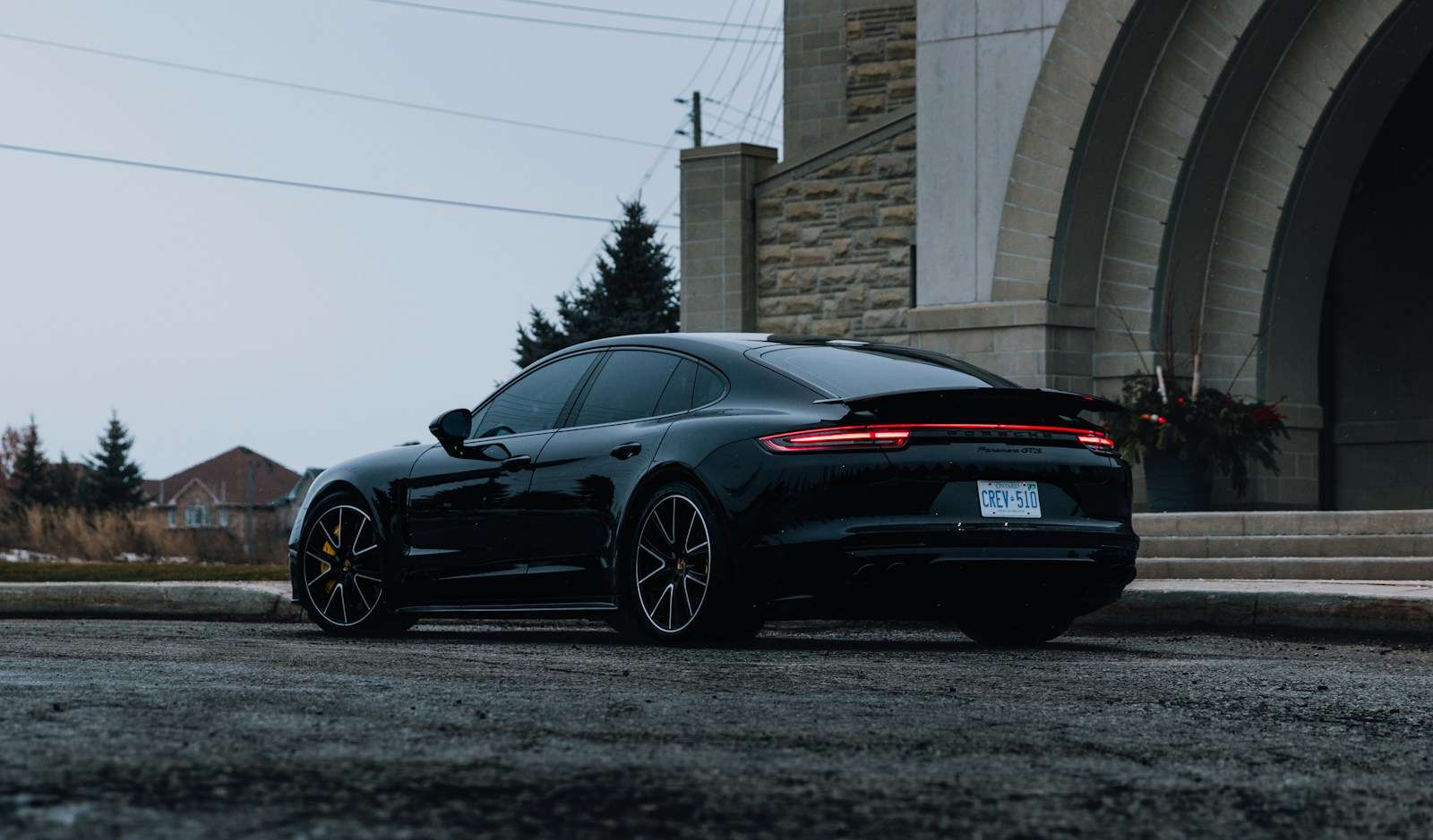 Black Porsche Panamera parked near a stone archway