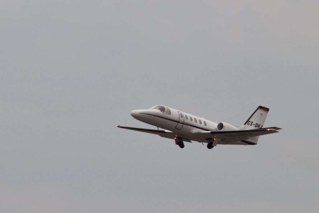 A Cessna 550 Citation II business jet climbing after takeoff