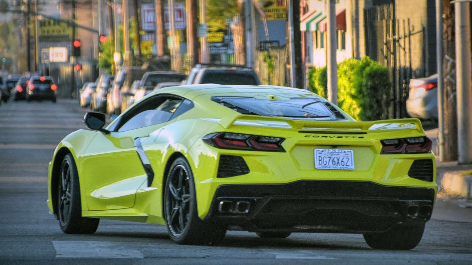 Yellow Chevrolet Corvette C8 seen from the rear on a city street