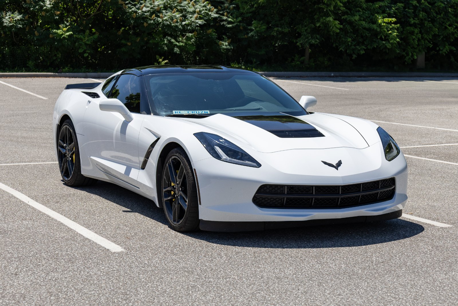 White Chevrolet Corvette Stingray parked outdoors, seen from the front three-quarter angle