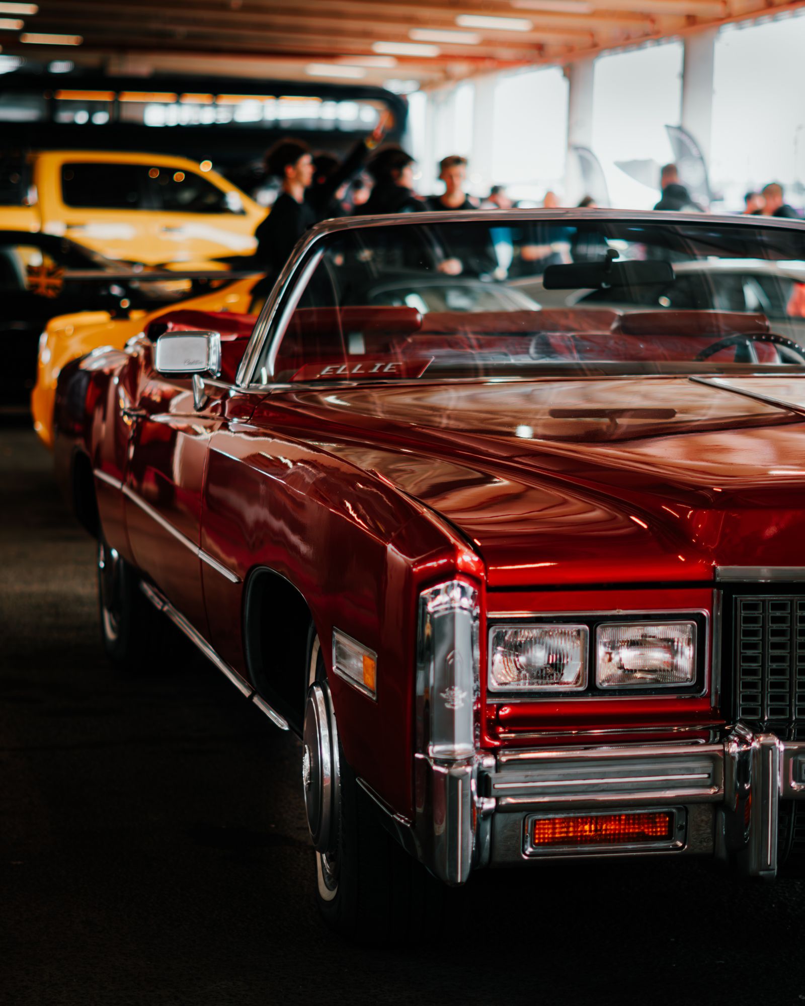 Red classic Cadillac Eldorado displayed at an indoor collector car show