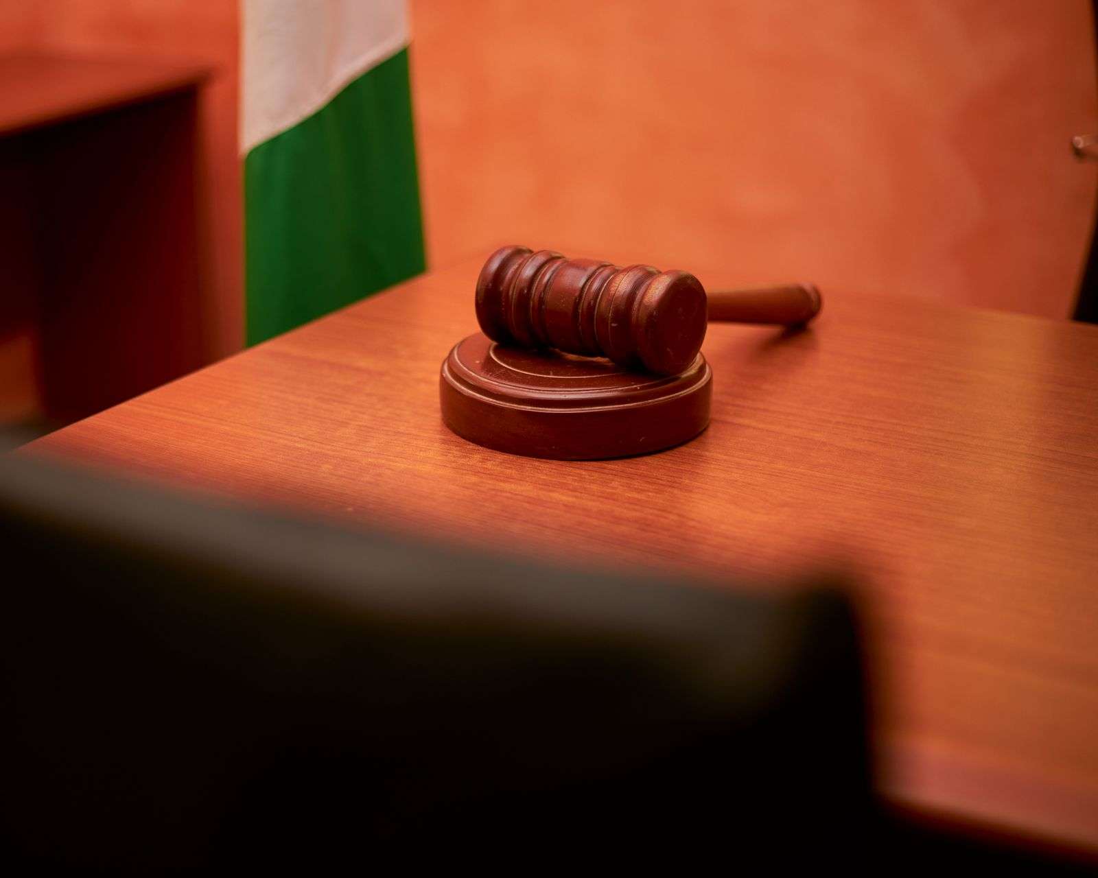 A wooden gavel resting on a courtroom desk