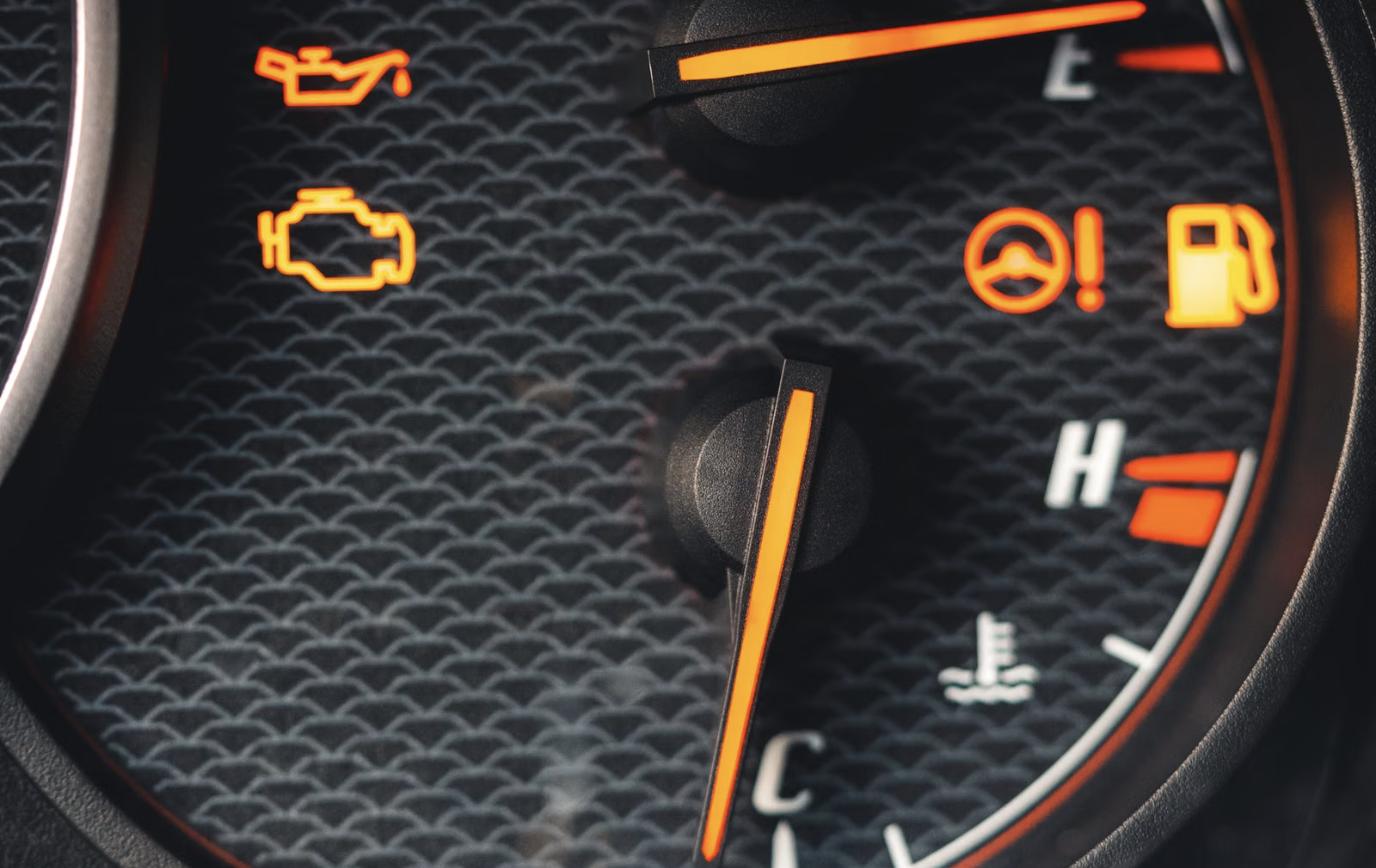 Car dashboard lit up with multiple warning lights