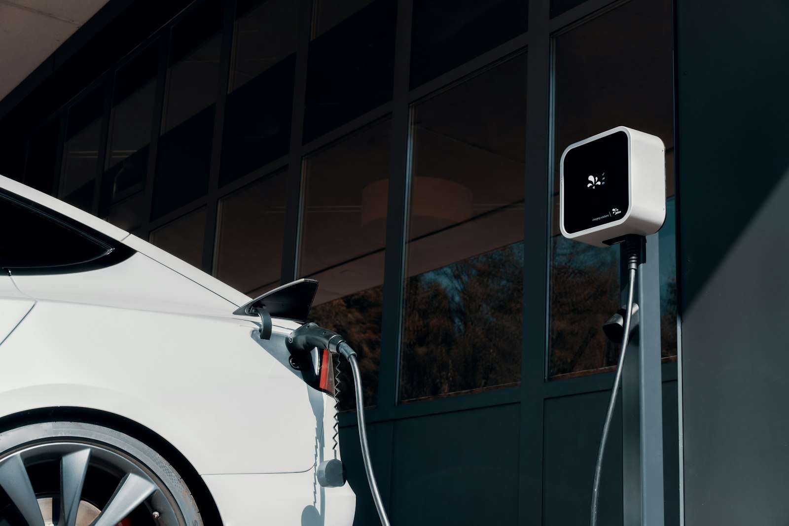 A white electric car charging, the technology the California gas car ban was built around