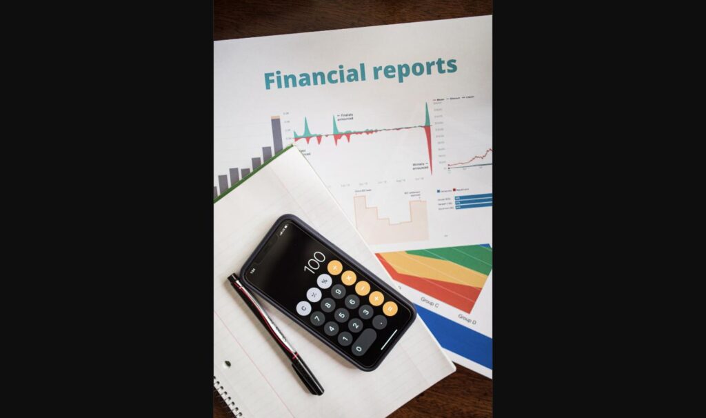 Financial reports and a calculator, representing the accounting adjustments behind Faraday Future's Nasdaq compliance fix