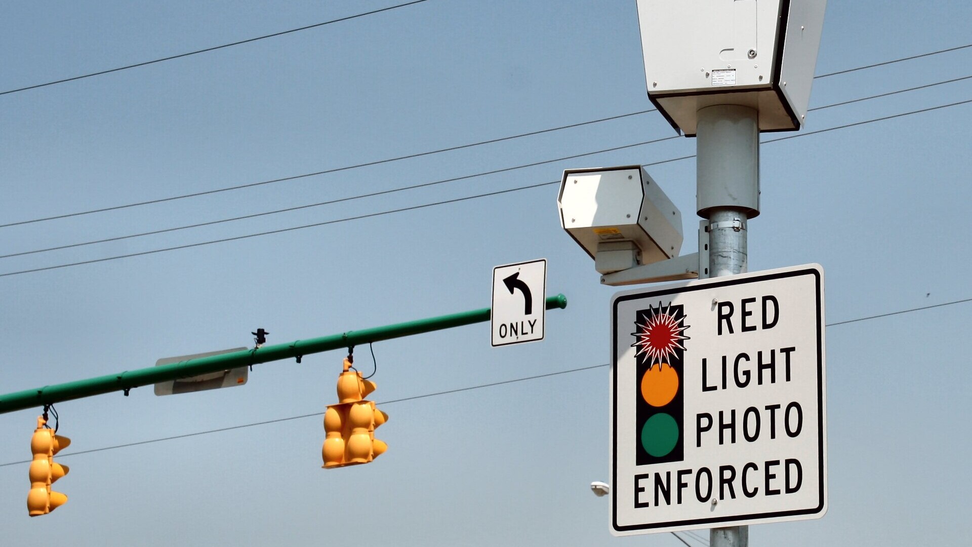 Red light camera and Red Light Photo Enforced sign at an intersection