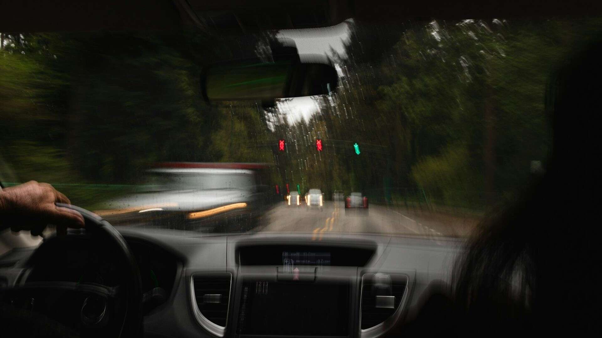 a person driving a car on a road with traffic lights