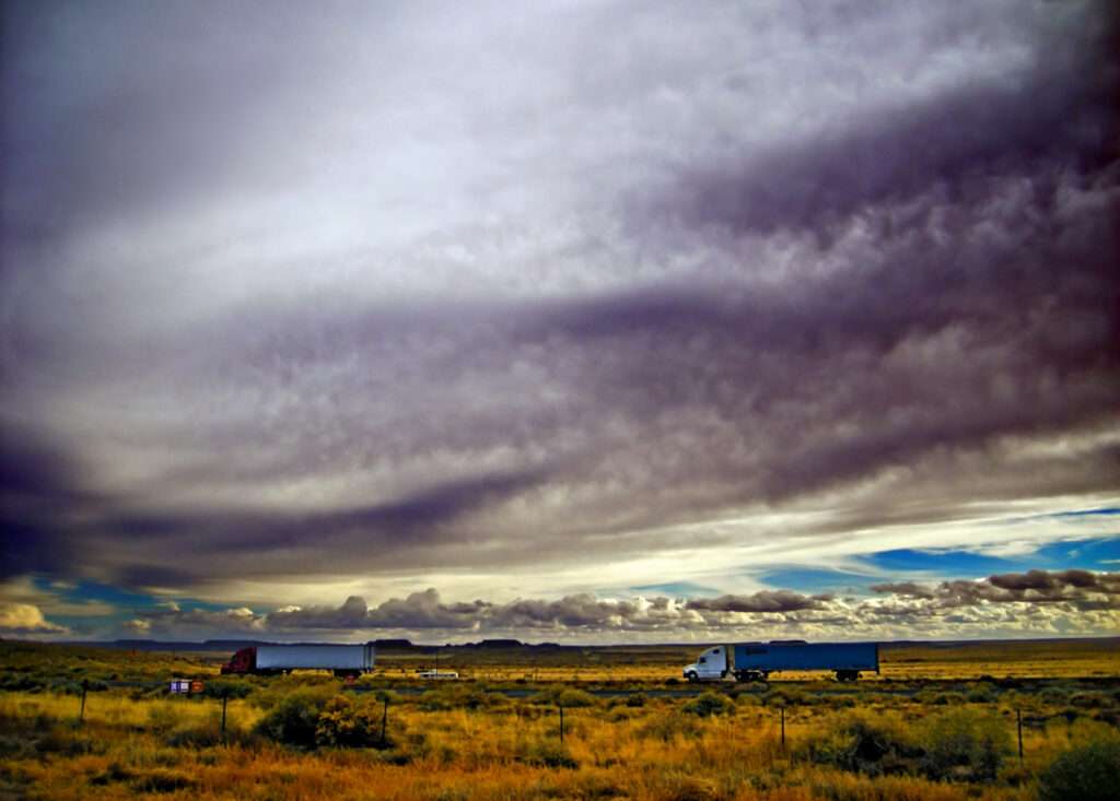 Trucks on Interstate 40 under storm clouds in east-central Arizona