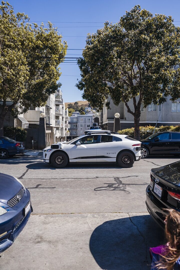 A white self-driving car on a city street