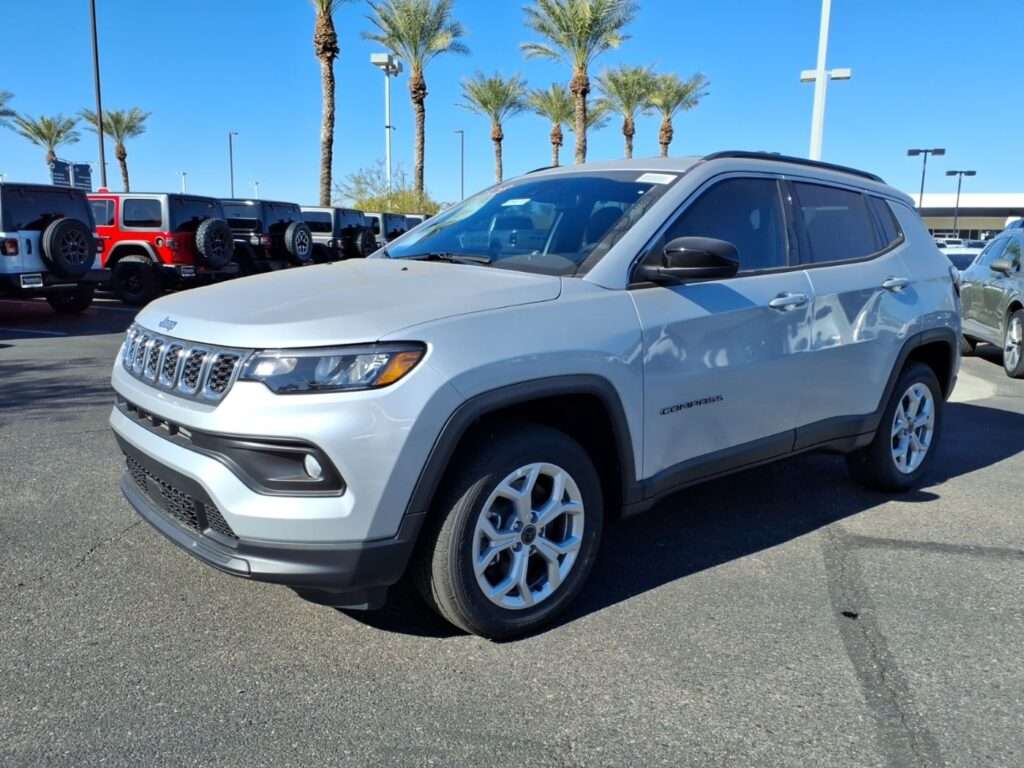 A silver Jeep Compass Latitude parked at a dealership