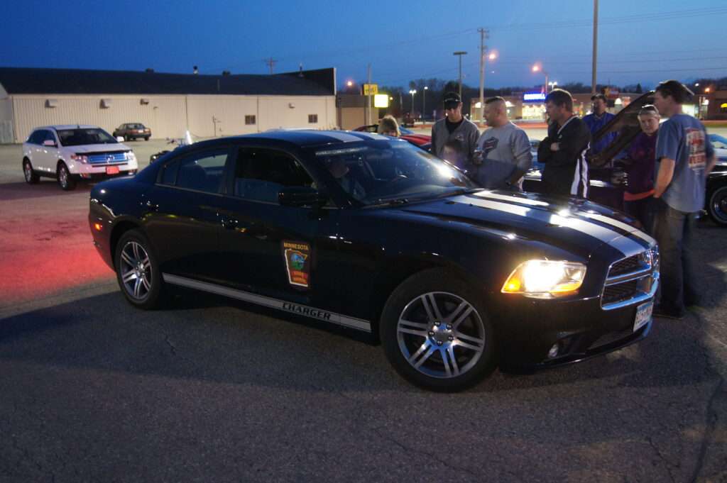 A black Minnesota State Patrol Dodge Charger parked at dusk