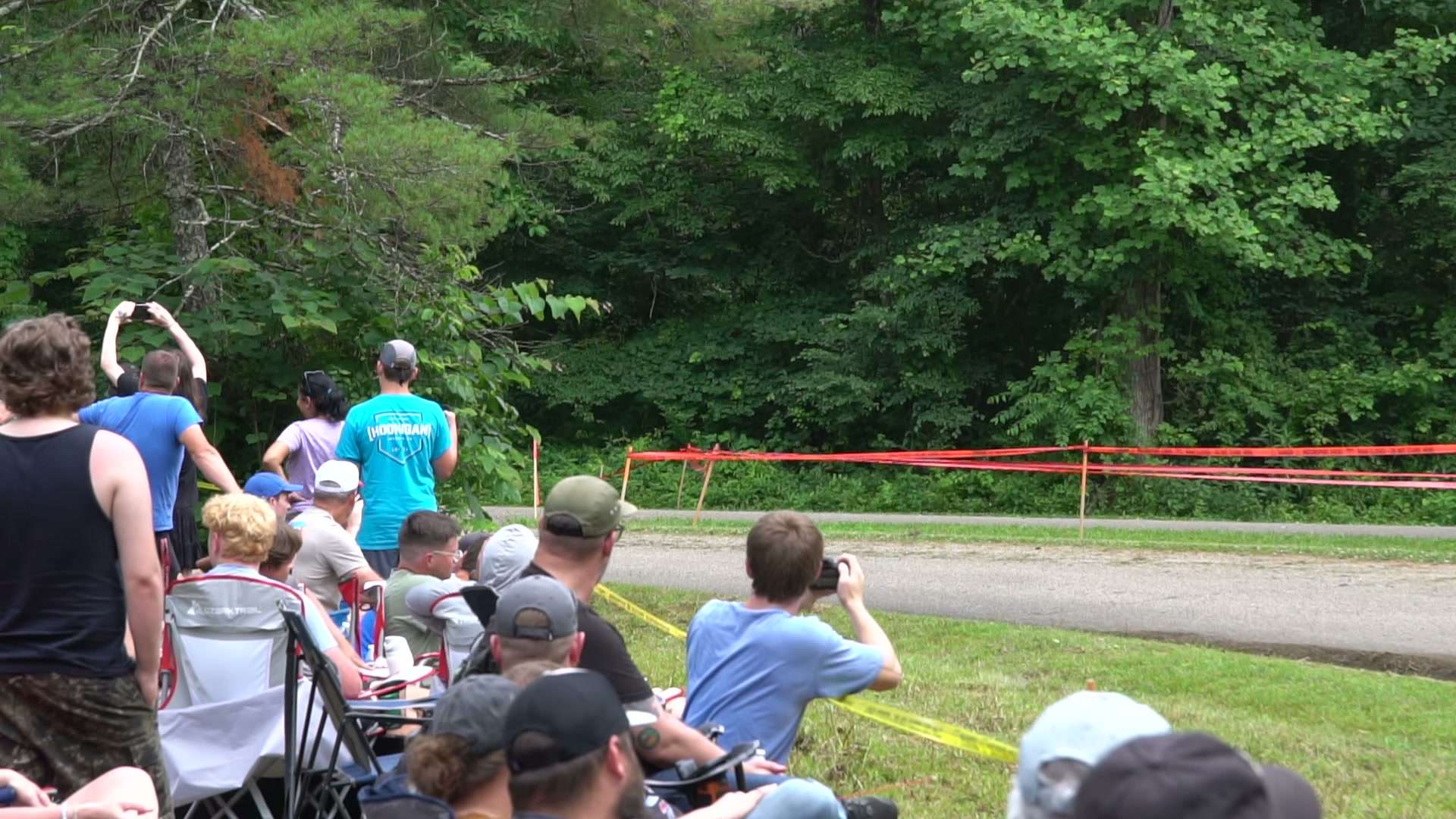 Spectators watching from behind caution tape at the Southern Ohio Forest Rally
