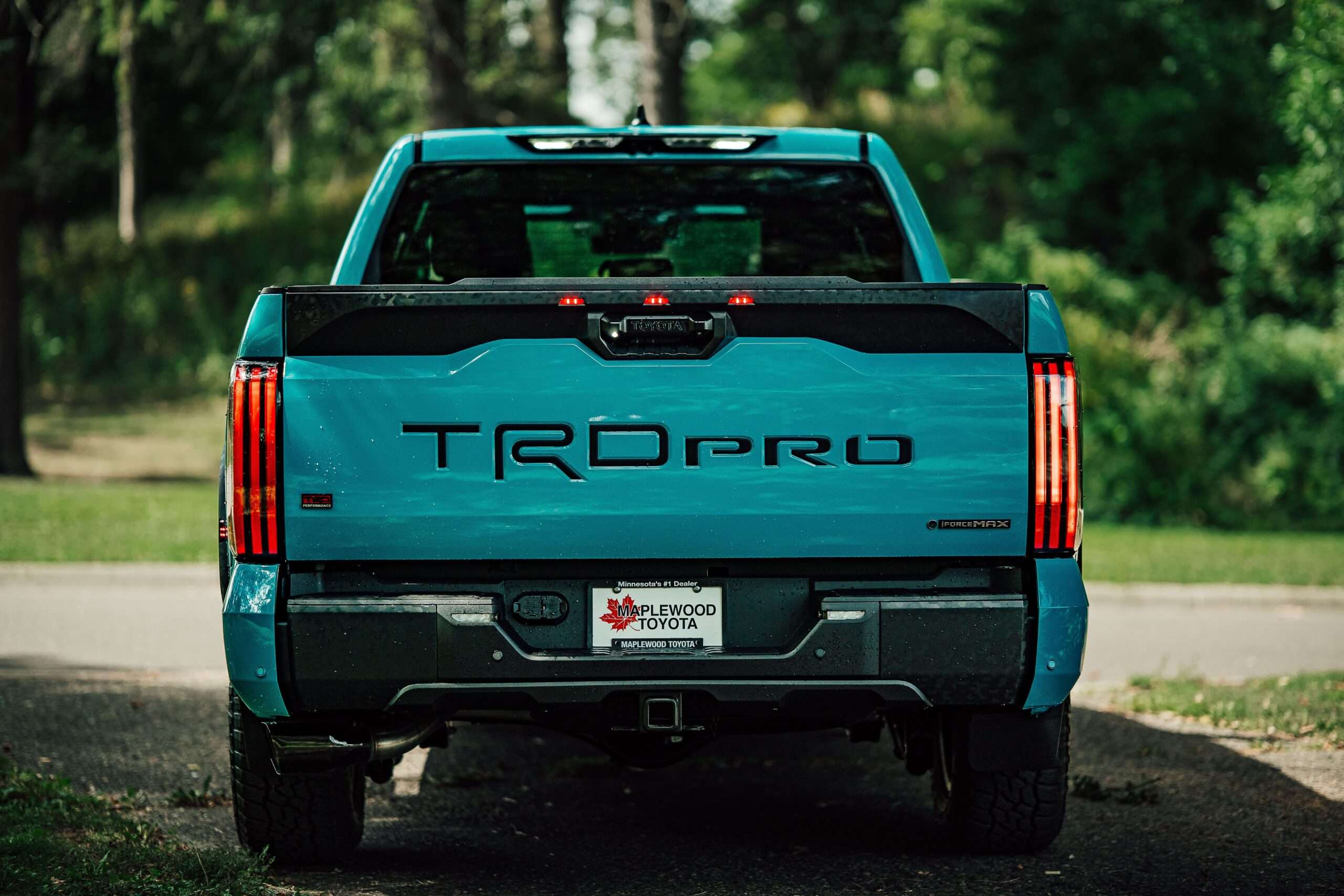 Rear view of a blue pickup truck, showing the tailgate area where backup camera wiring is routed