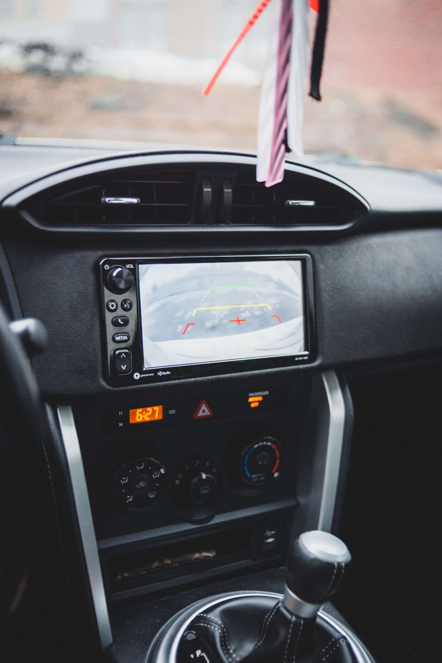 Dashboard screen in a car displaying a reversing camera view with guide lines