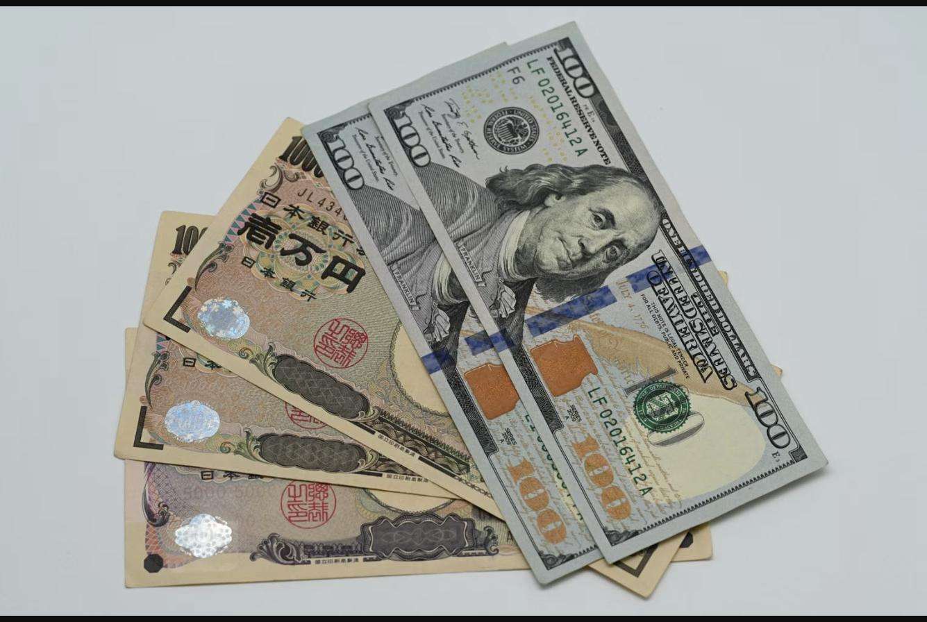 US hundred dollar bills fanned over Japanese yen notes, illustrating the Plaza Accord currency realignment