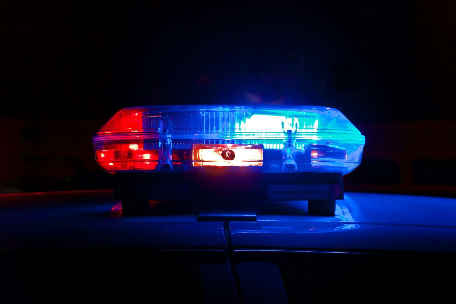 Red and blue police light bar flashing at night