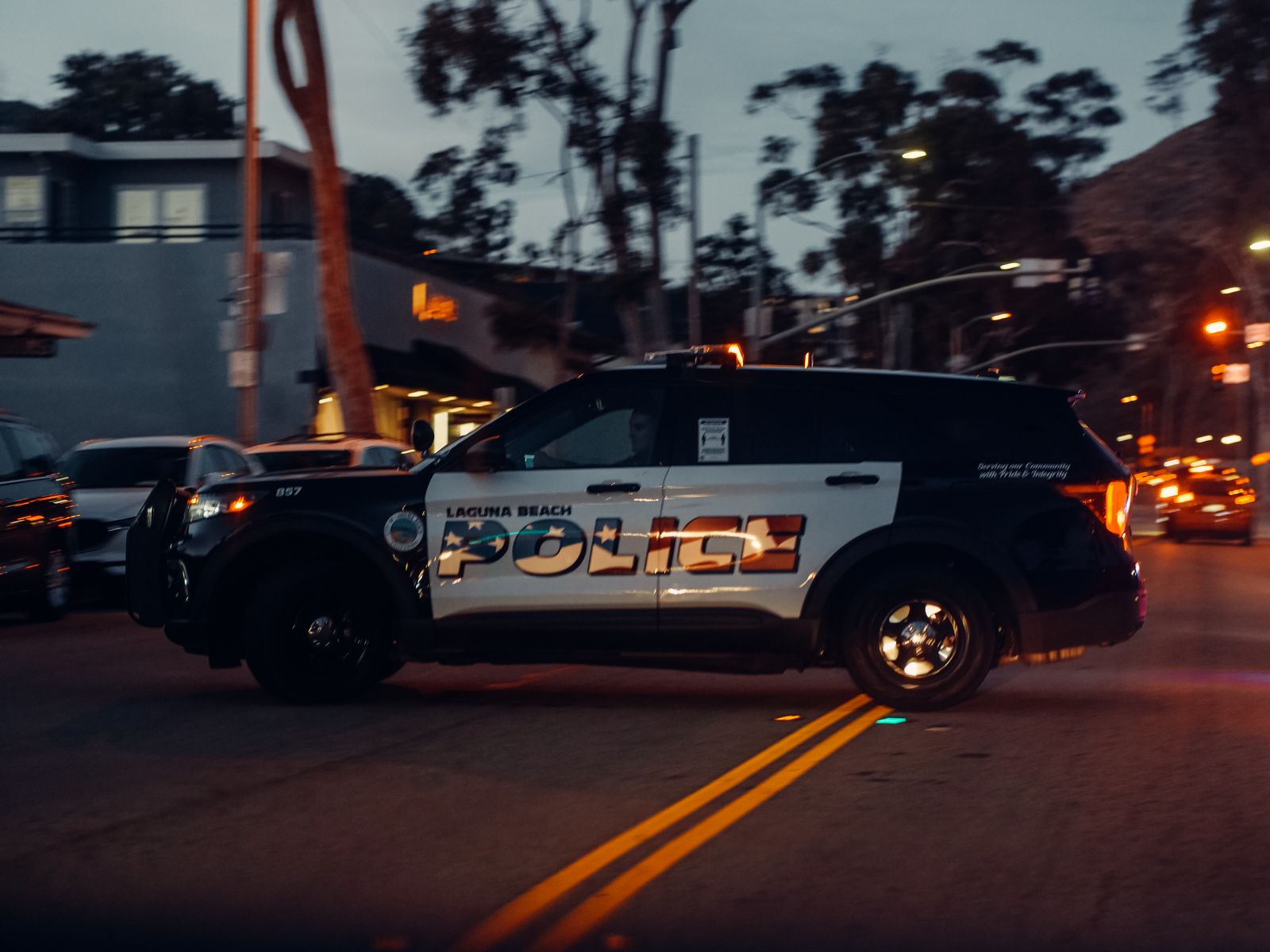 A police vehicle patrolling a city street at night