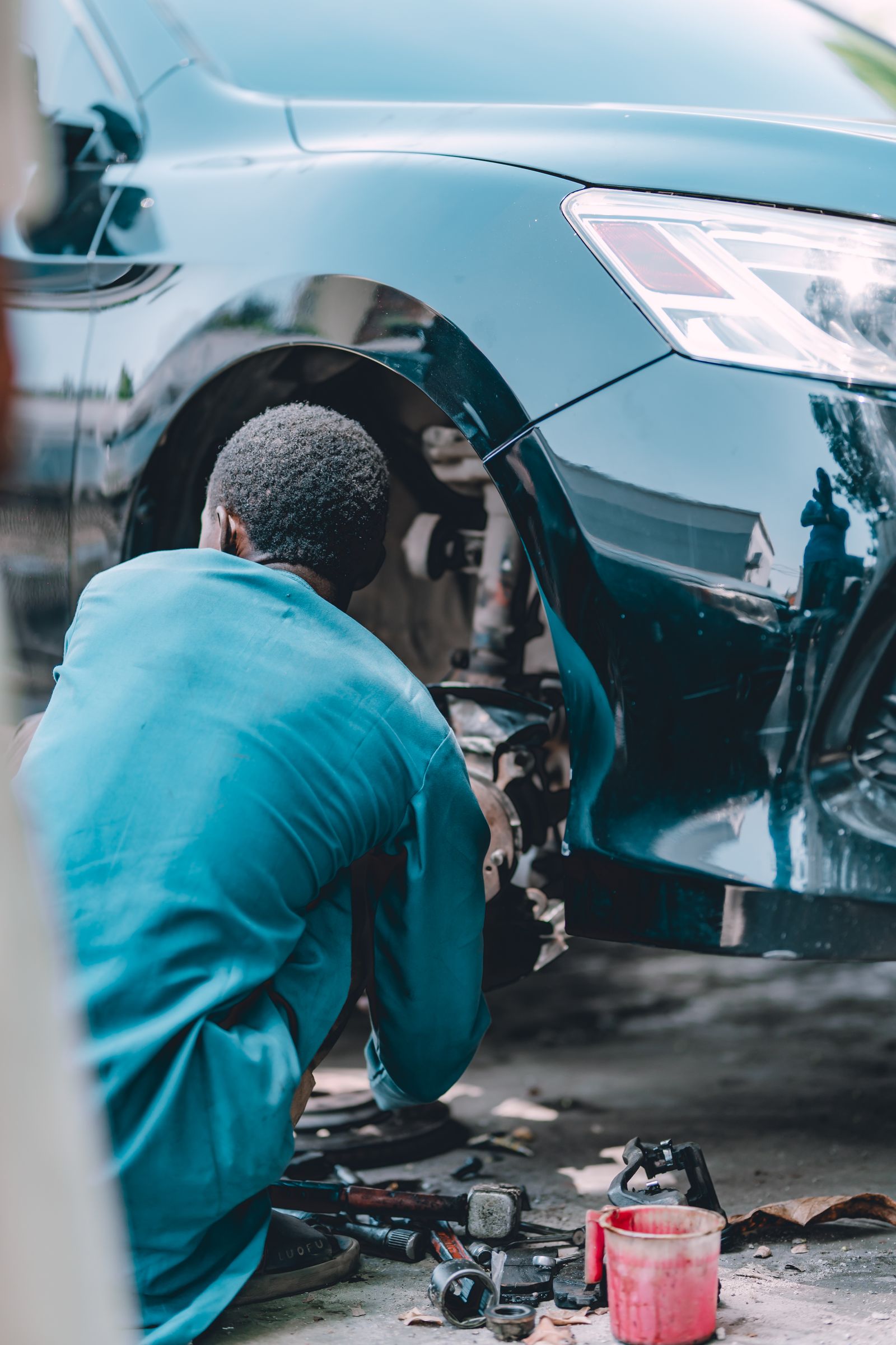 Mechanic repairing a car brake assembly in a service garage