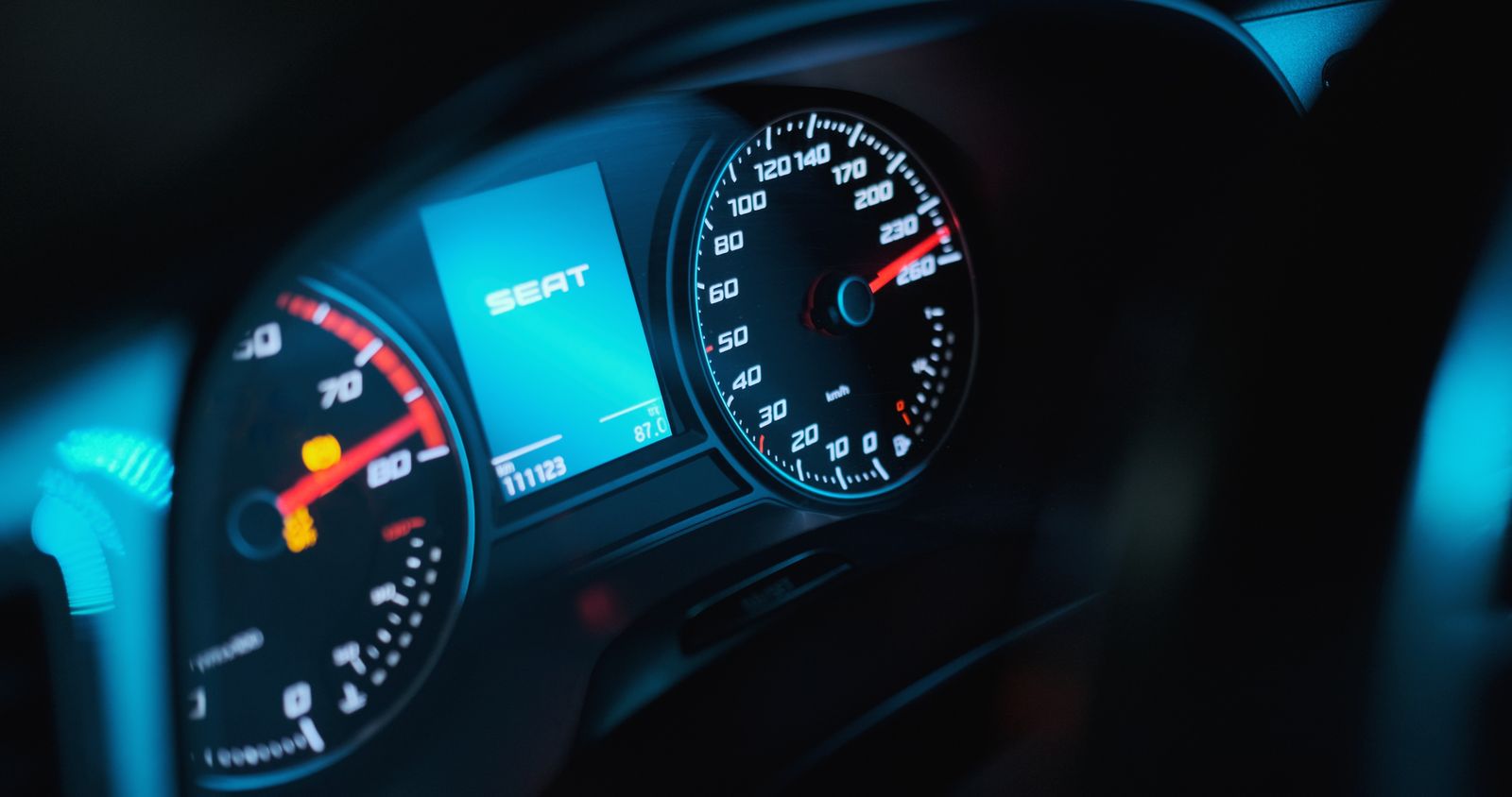 A car speedometer and digital display showing a high road speed