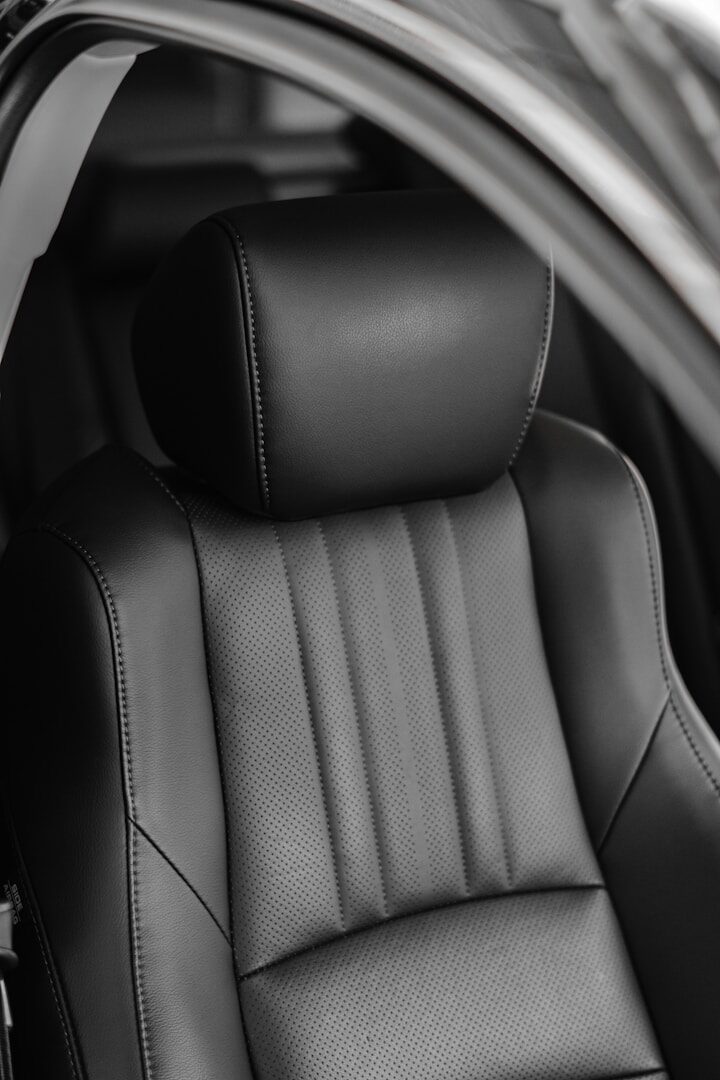 a black leatBlack leather car seat interior, the kind of hiding spot where a tracker can go unnoticedher seat