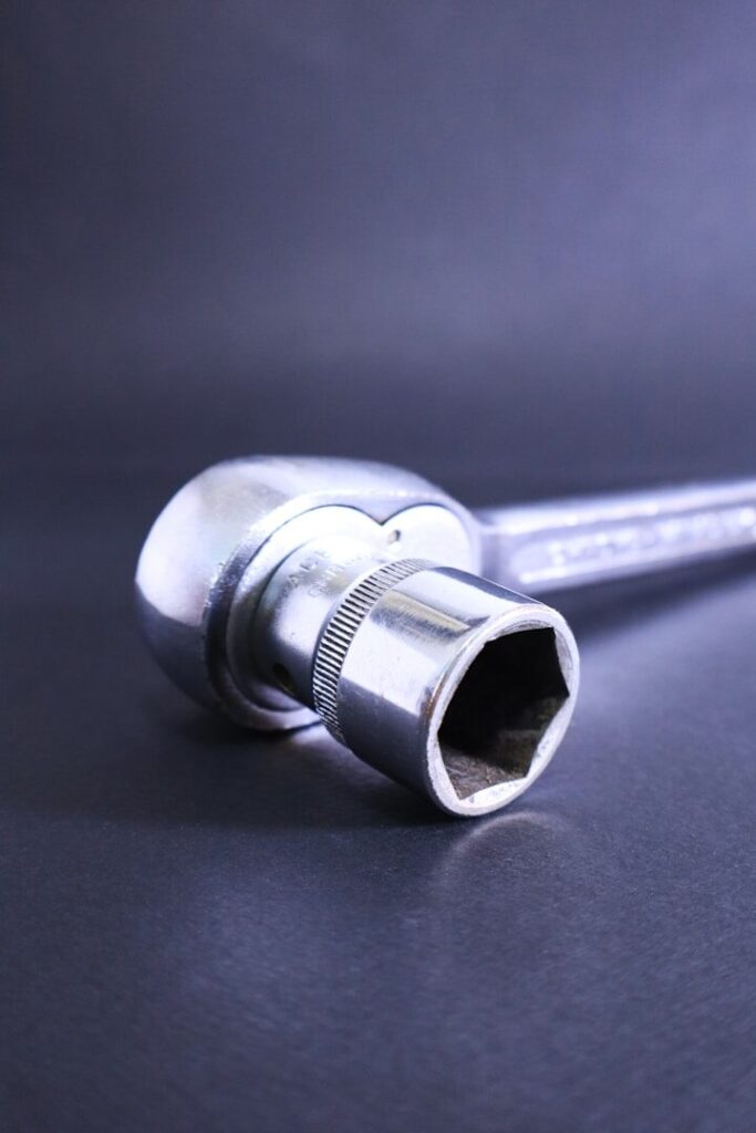 A socket wrench rests against a dark background