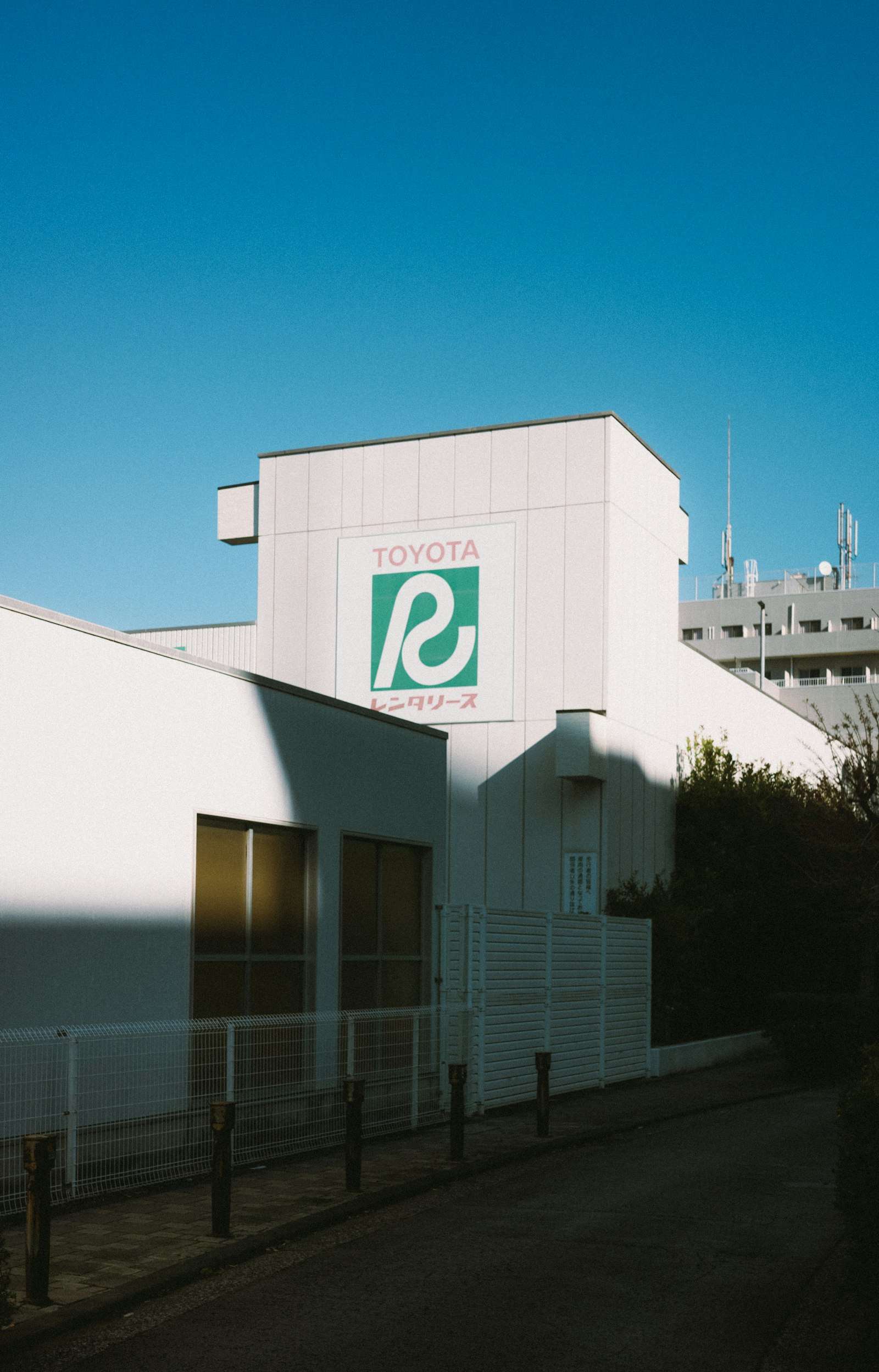 Toyota logo on a building facade under a blue sky