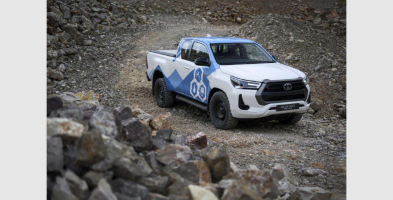 Toyota's hydrogen fuel cell Hilux prototype, badged H2, driving on a gravel test track
